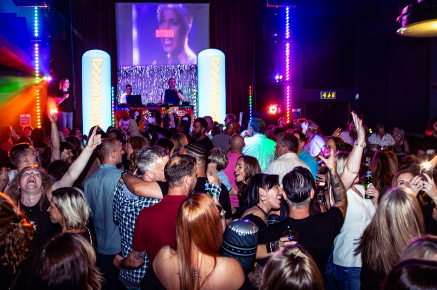 90s videos on the big screen above a singing crowd